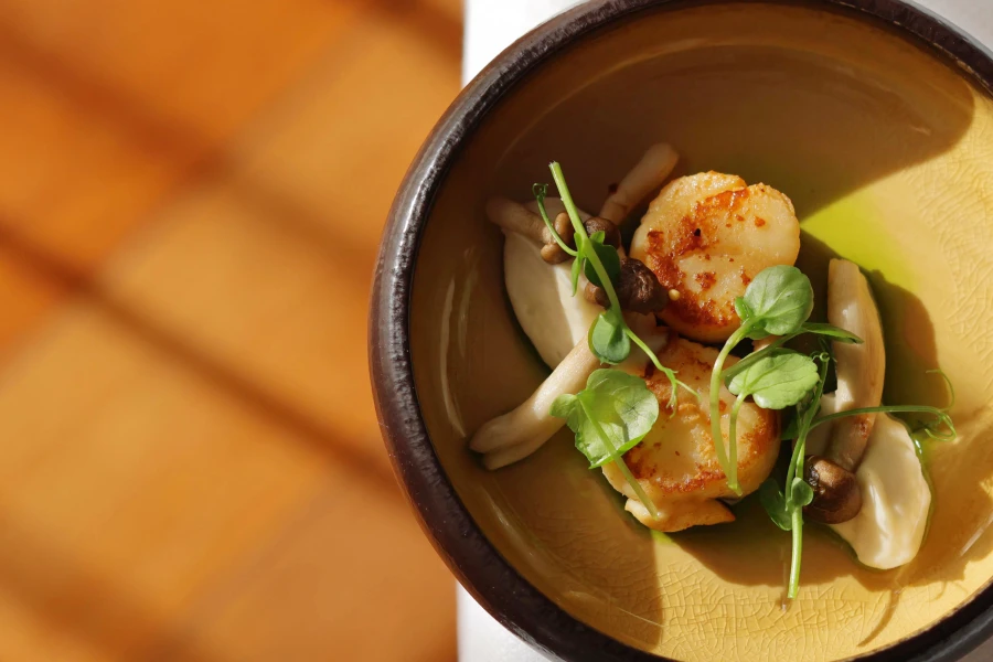 Gæst spiser kammusling til forret i Restaurant Holger