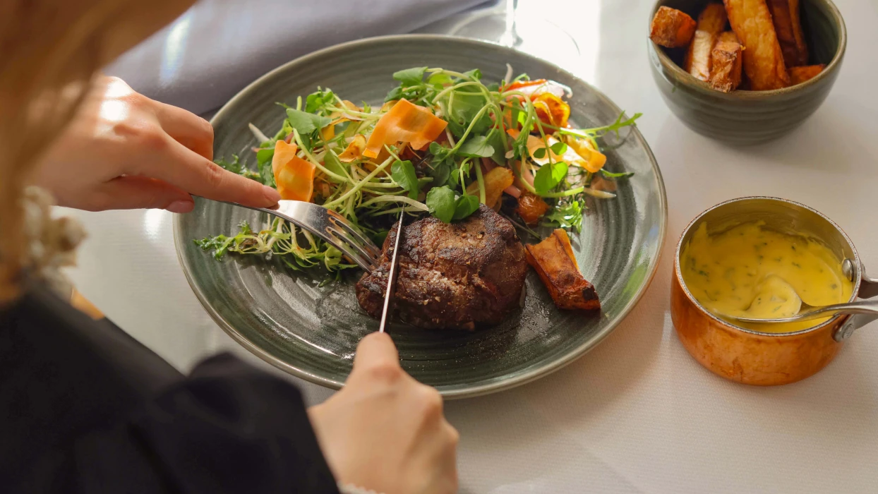 Gæst nyder steak med pomfritter i Restaurant Holger